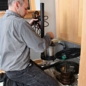 plumber installs home sump pump